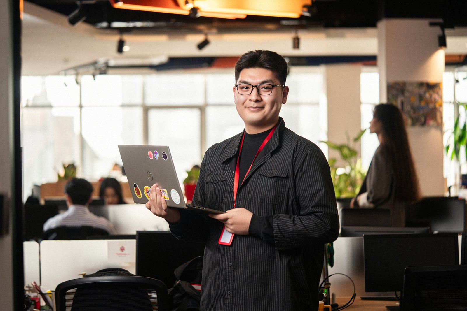 Young professional working with a laptop in an office hall